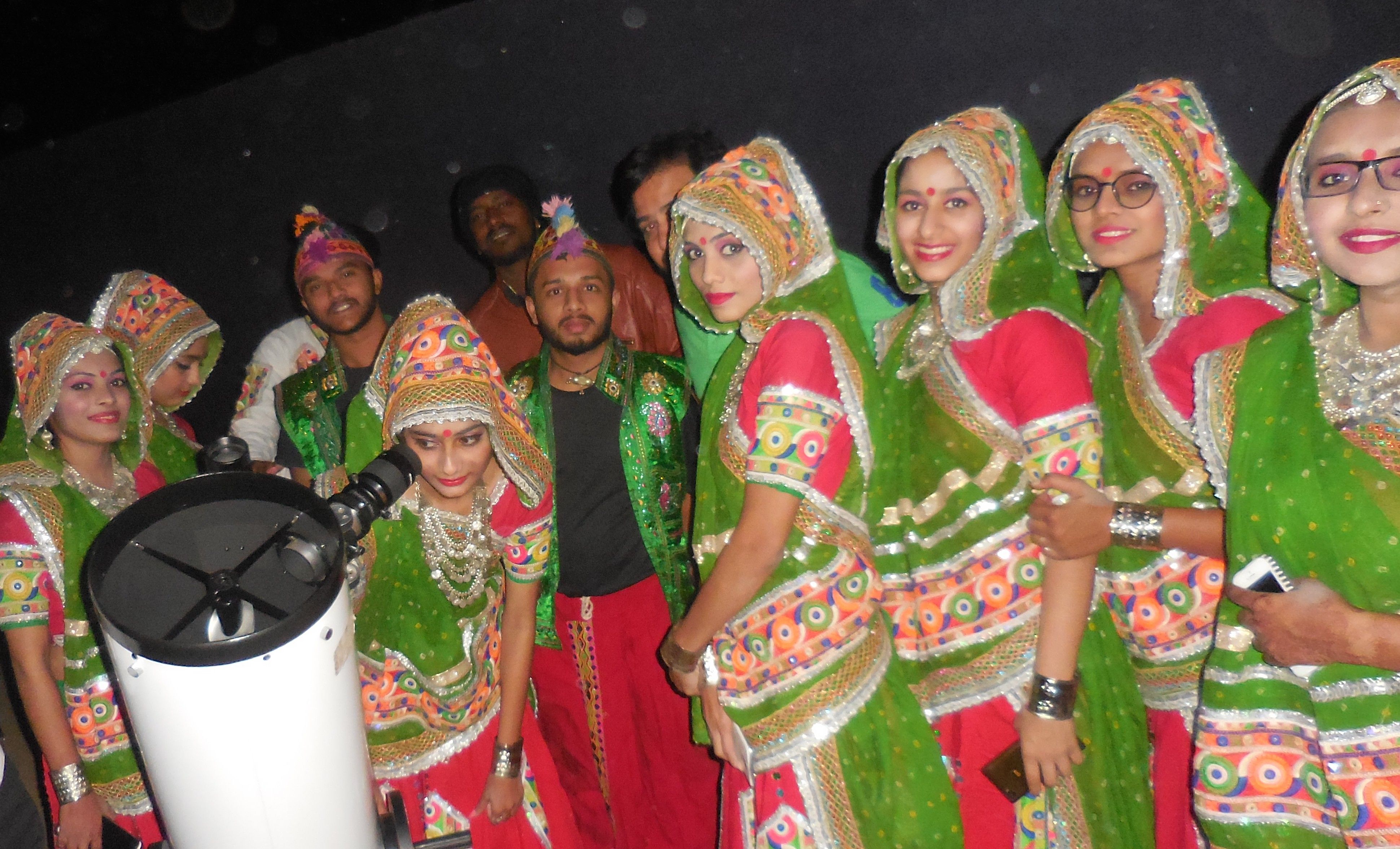 A group of people stargazing in the desert at night.